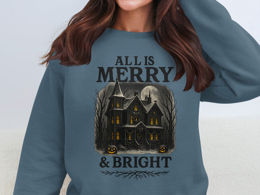 Indigo blue haunted holiday sweatshirt with “All Is Merry & Bright” text and detailed gothic house illustration. Pumpkin lanterns and glowing windows add eerie beauty to the festive theme. Soft unisex fleece crewneck ideal for alternative Christmas styling. Designed and printed in the UK by The Print Harbour, combining spooky charm with winter warmth.